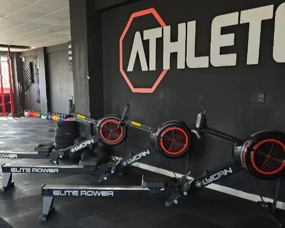 Rowing machines under the Athletes MX wall sign in Coyoacán